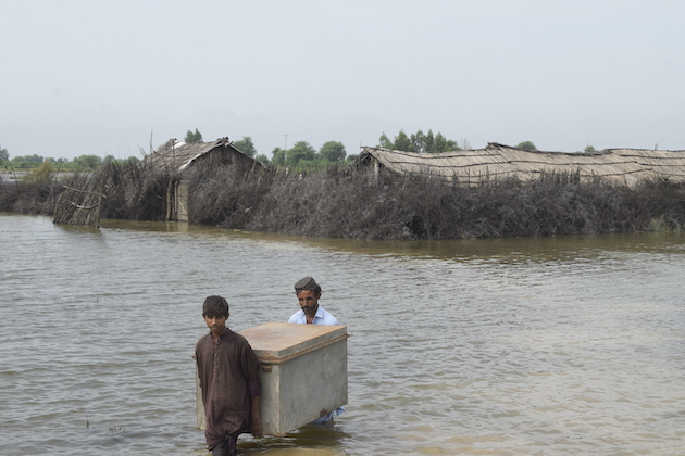 Un padre y su hijo retiran sus pertenencias de su casa dañada por las inundaciones en Taluka, Shujabad, Distrito Mirpurkhas Taluka, Shujabad, Distrito Mirpurkhas.  Crédito: Fundación de Investigación y Desarrollo (RDF)
