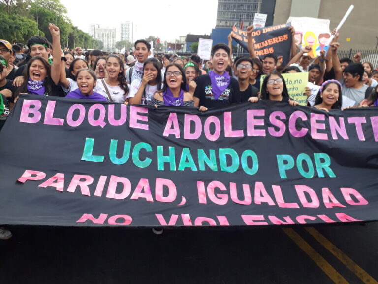 Mujeres y hombres jóvenes en Lima, la capital de Perú, ondearon una bandera gigante durante la marcha por el Día Internacional de la Eliminación de la Violencia contra la Mujer el 25 de noviembre de 2019, antes del estallido de la pandemia de COVID-19 que ha exacerbado tales violencia en.  America latina.  AMIGOS: Mariela Jara/